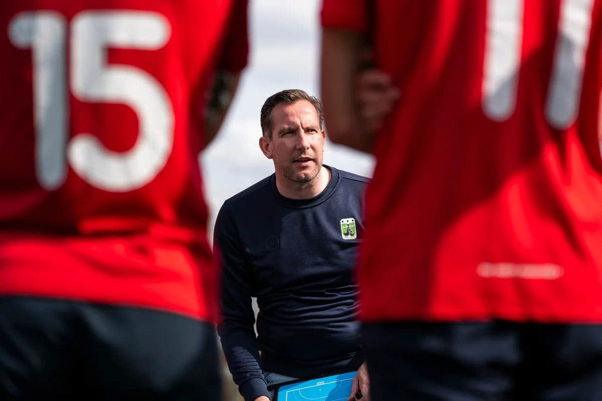 Football coach briefing players on the training ground