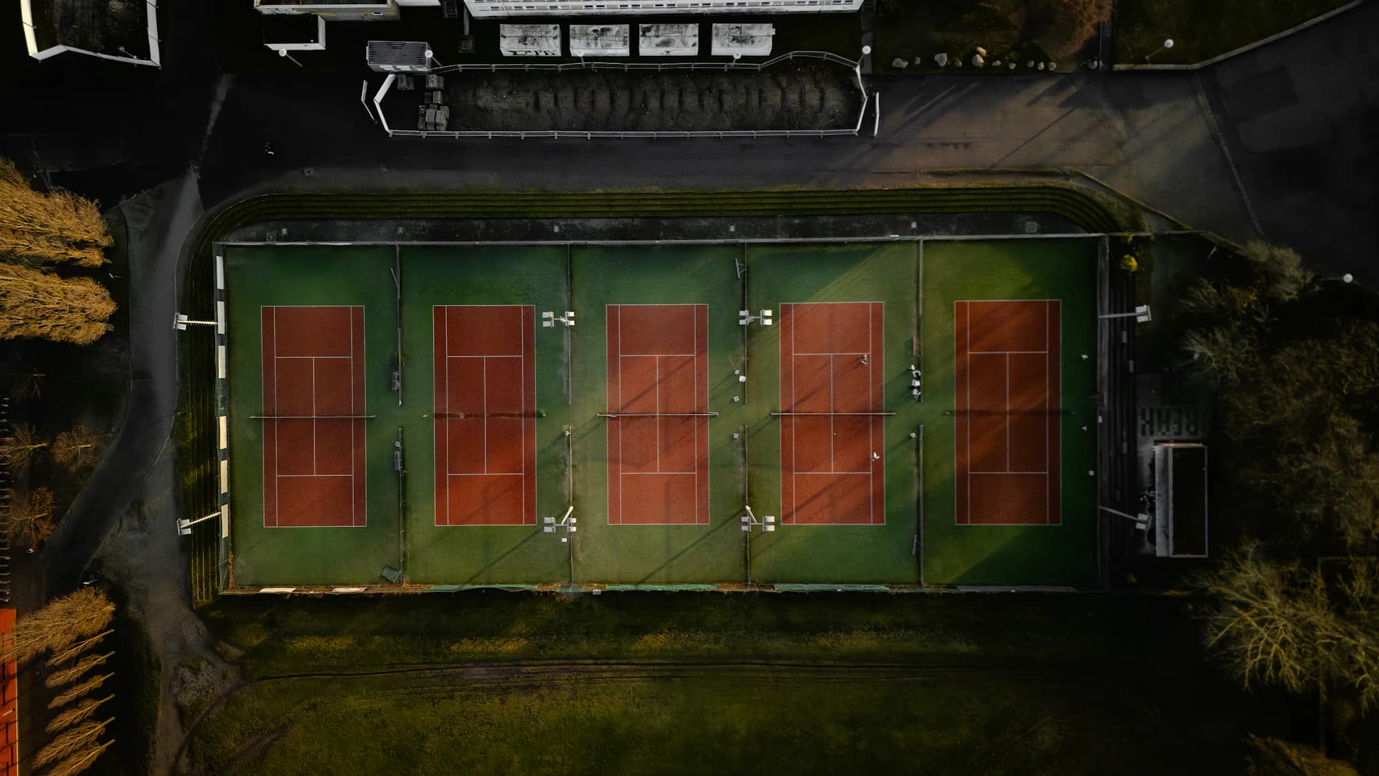 Aerial view of tennis courts in warm evening light.