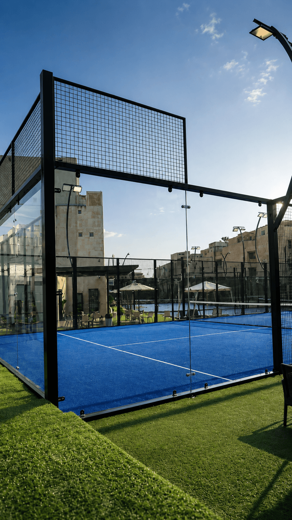 Blue padel court enclosed by glass