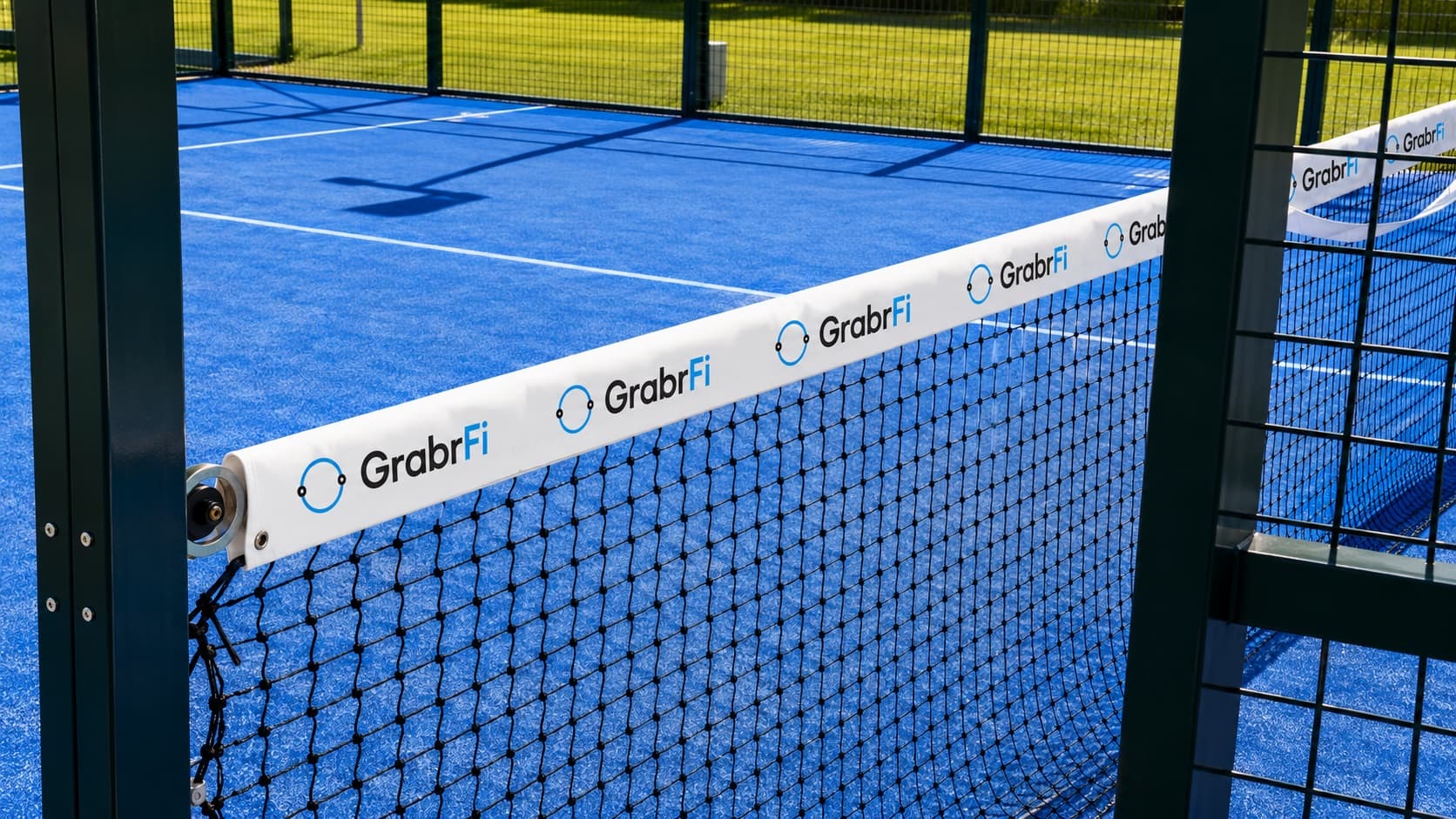 GrabrFi sponsor branding on a padel court net